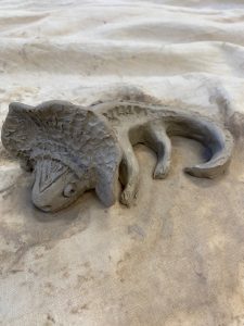 Savist voolitud kala kujuline reljeef valgel kortsus tekstiili