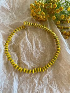 Kollastest lilleõitest tehtud kee kortsus paberi peal