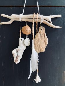 Merest uhutud puidust ja merekarpidest tehtud kaunistus, mis ripub puidust seina peal